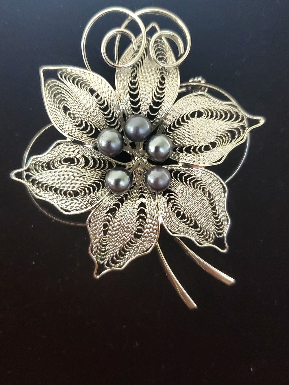 Vintage silver tone filigree flower brooch featuring grey faux pearls